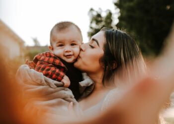 woman kiss a baby while taking picture