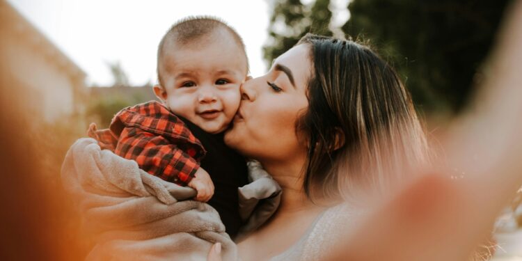 woman kiss a baby while taking picture