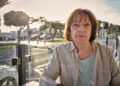 woman in white jacket sitting on bench during daytime