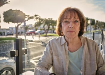 woman in white jacket sitting on bench during daytime