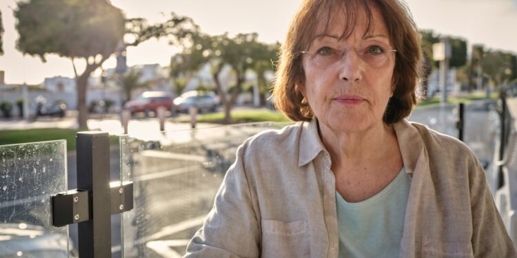 woman in white jacket sitting on bench during daytime